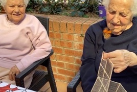 Two elderly ladies release a butterfly from its cage Two elderly ladies release a butterfly from its cage