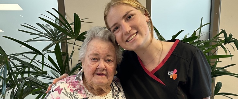 An elderly resident and young carer, smiling