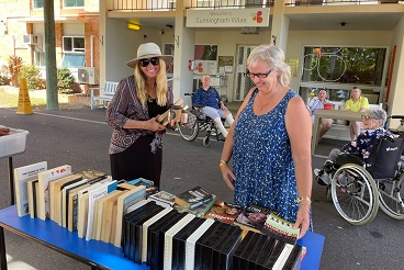 Two ladies smiling while shopping for secondhand books